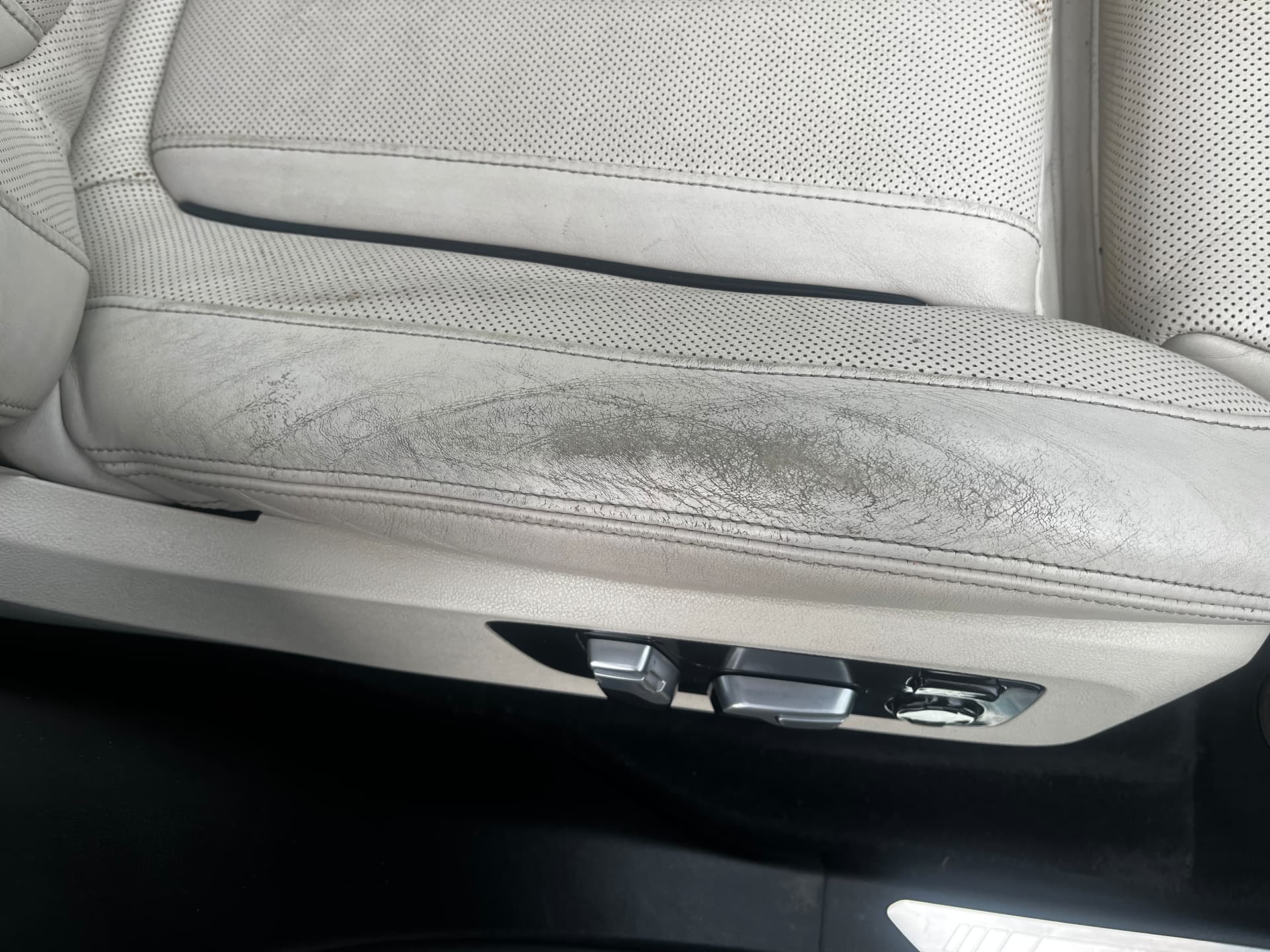 Cracked and worn light leather BMW seat bolster before restoration by PJ Leather Paint