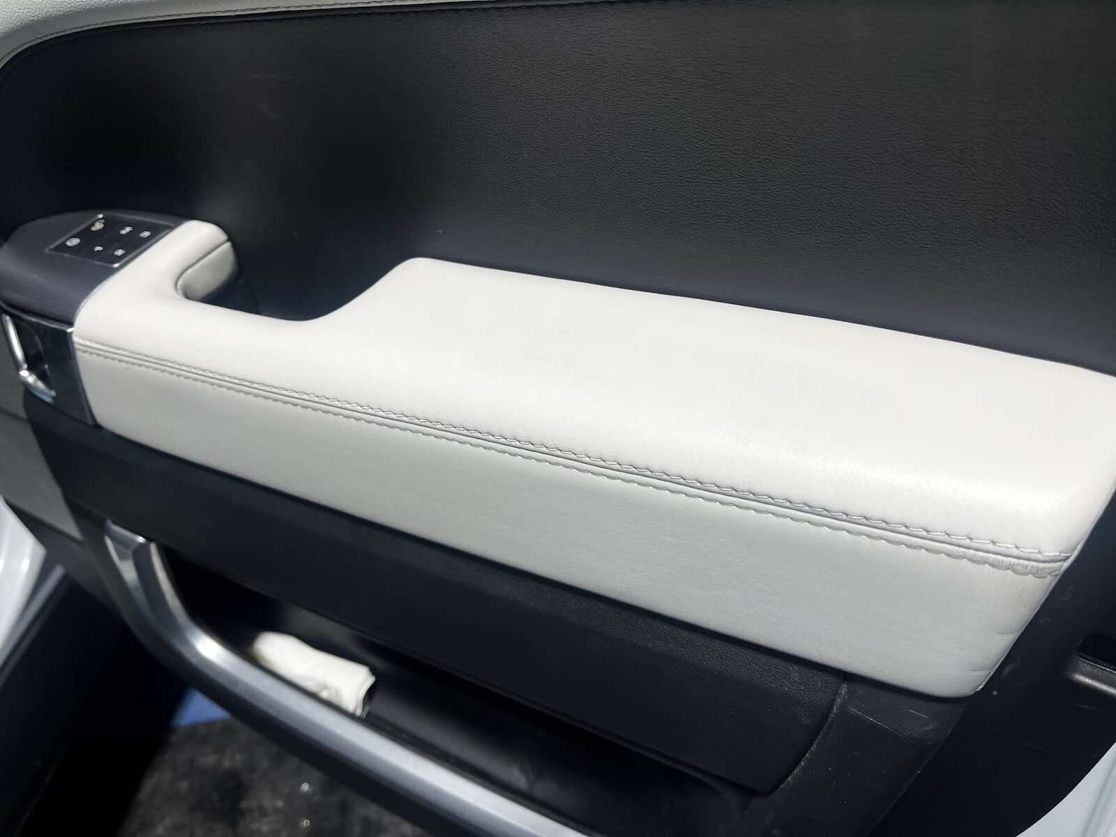 The same light grey leather Land Rover Defender door panel armrest after repair and recolouring by PJ Leather Paint