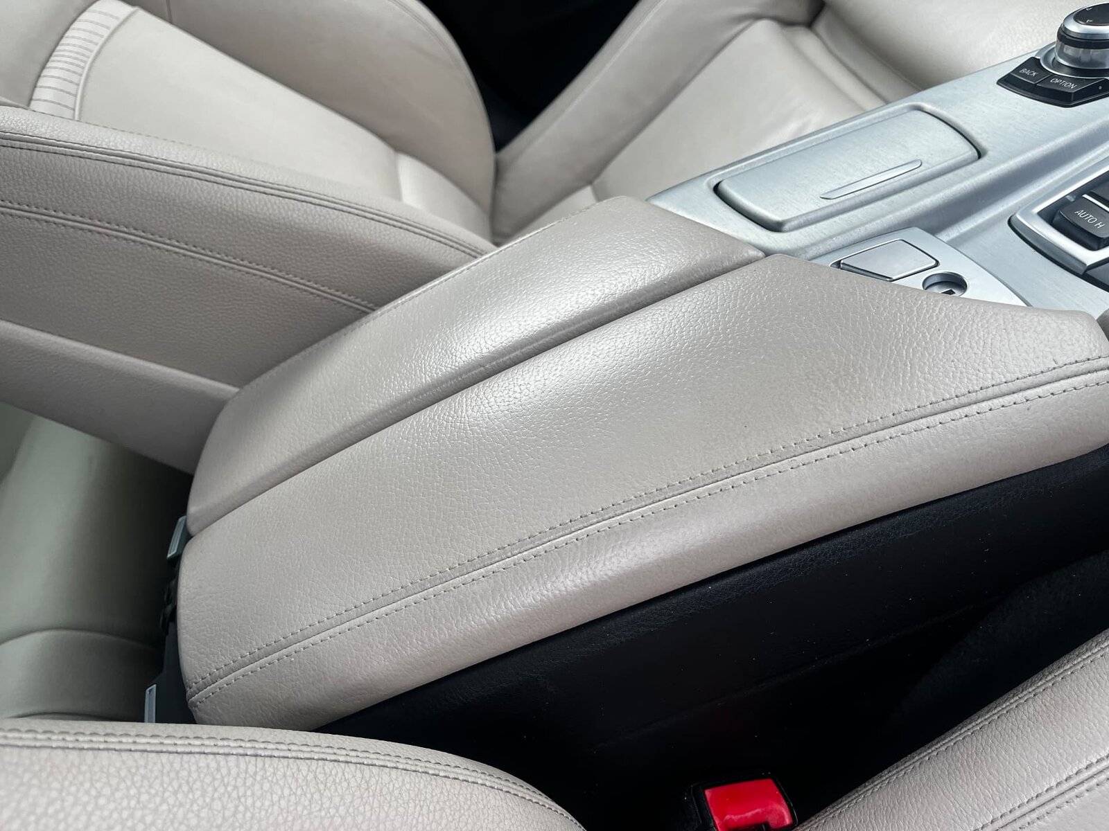 The same beige leather BMW centre console armrest after repair and recolouring by PJ Leather Paint
