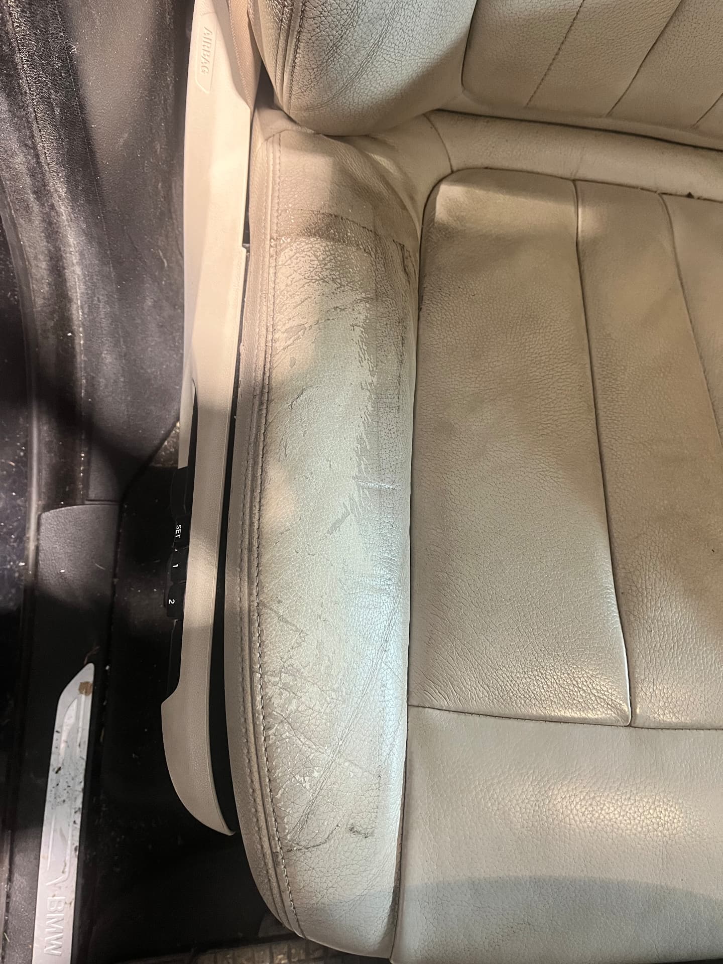 Cracked, worn light leather BMW seat bolster before restoration by PJ Leather Paint