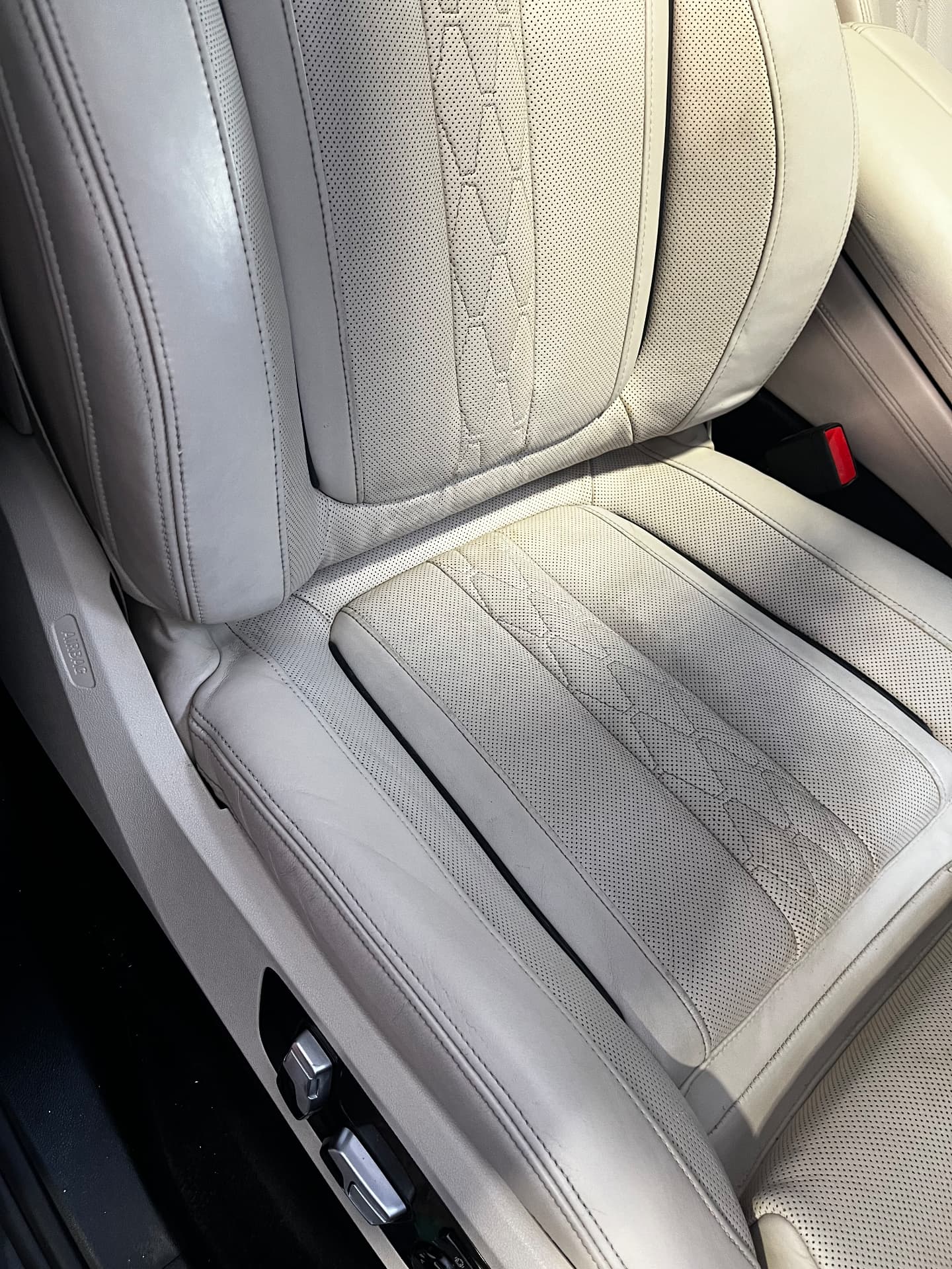 The same light leather BMW seat bolster after repair and refinishing by PJ Leather Paint
