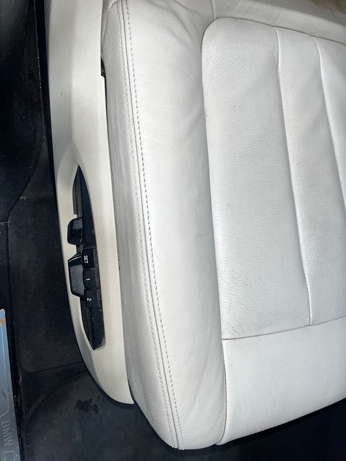 The same light leather BMW seat bolster after repair and refinishing by PJ Leather Paint