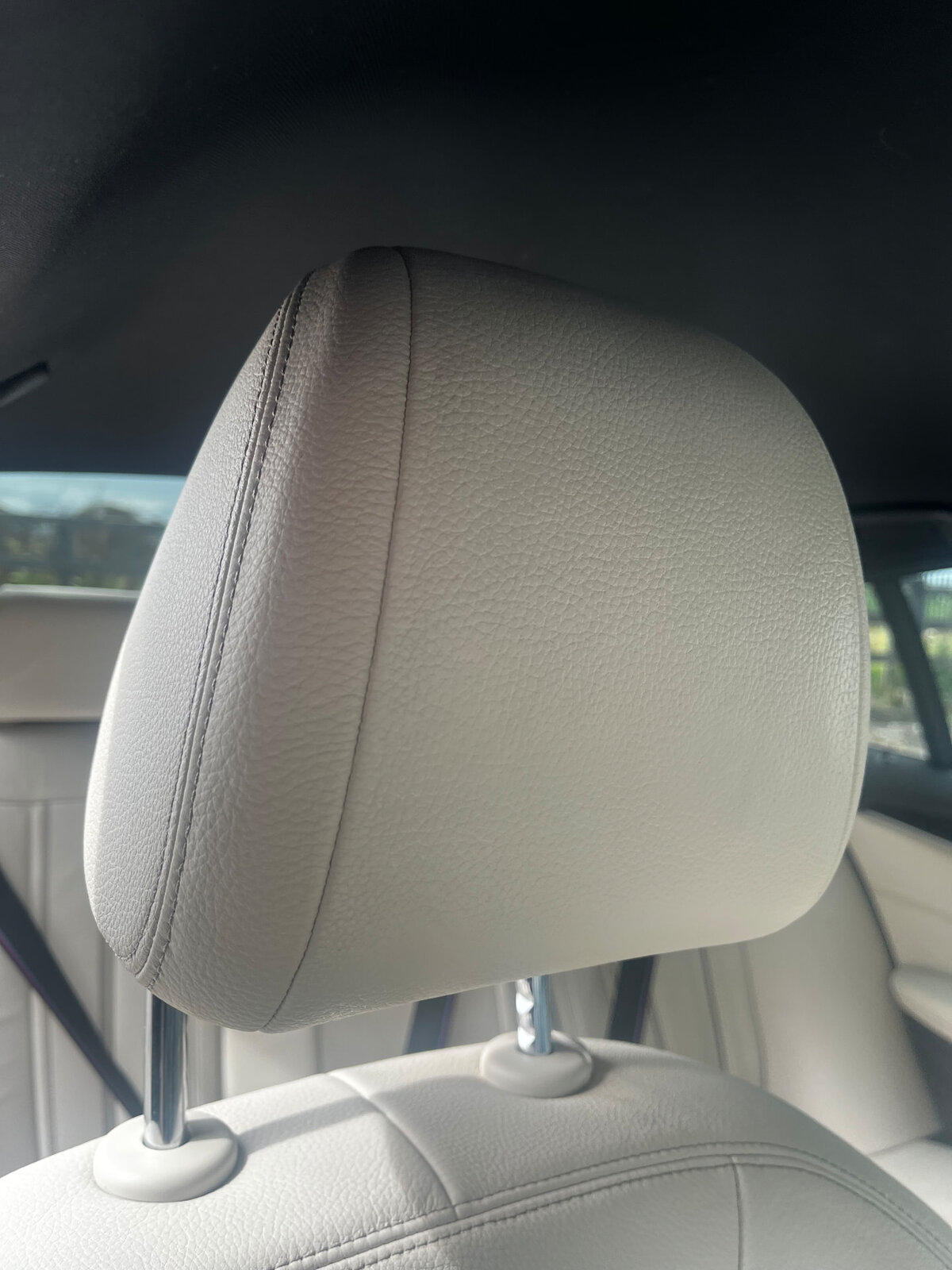 The same off-white leather car headrest after repair and recolouring by PJ Leather Paint