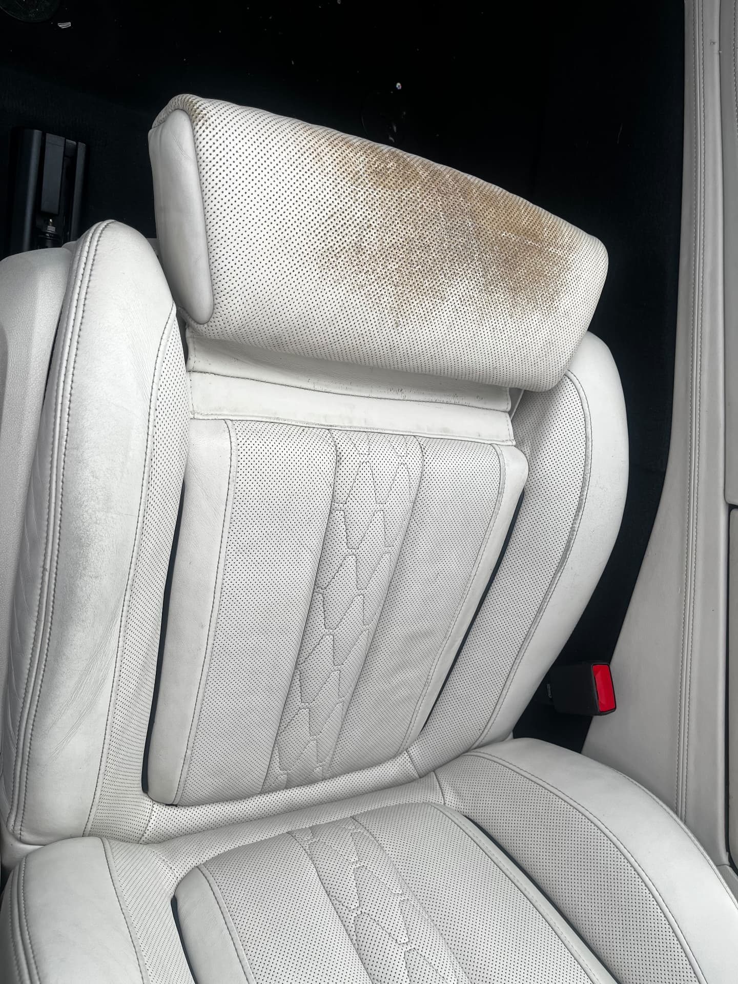 Heavily marked light leather BMW headrest before restoration by PJ Leather Paint